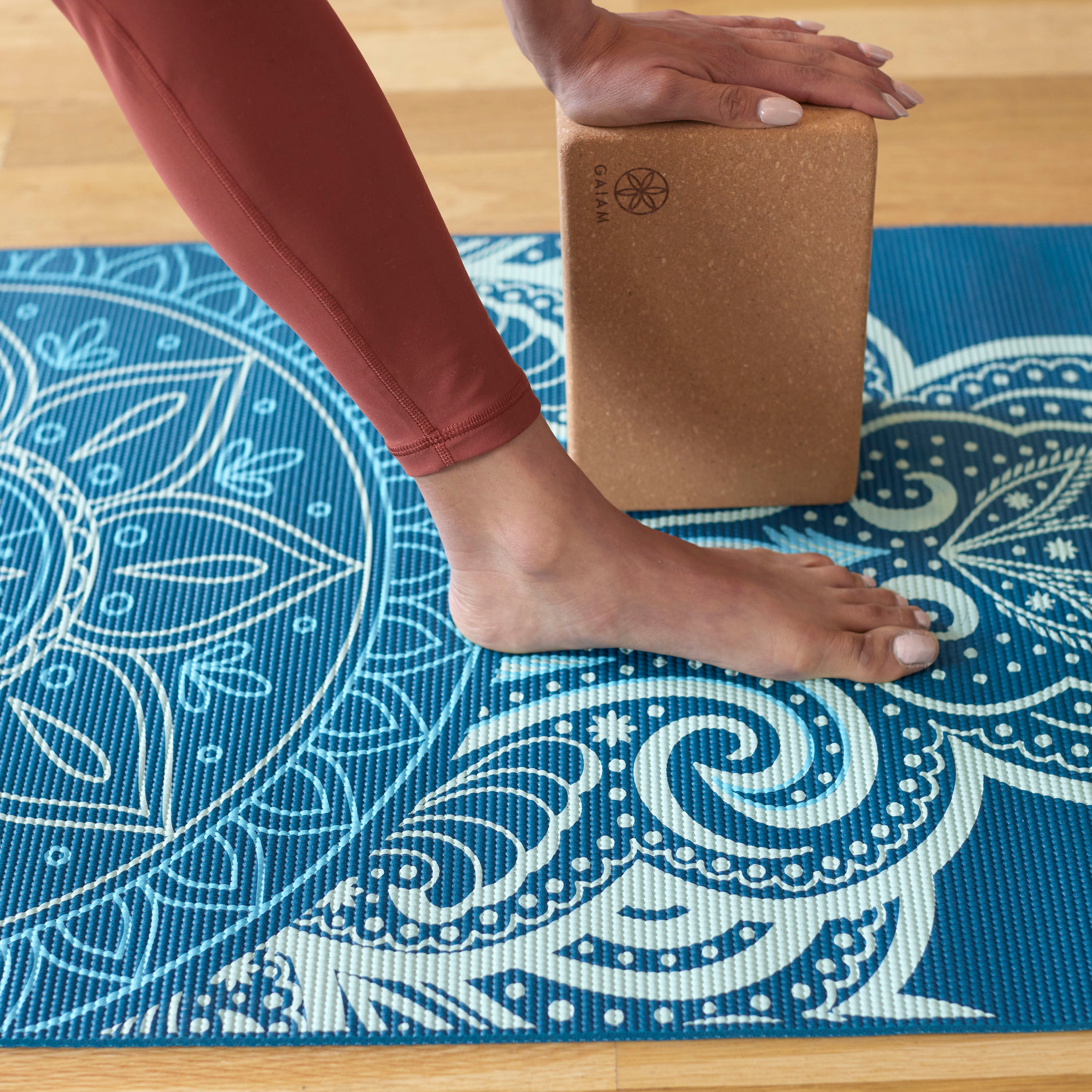 Persons hand on mat with block and hand on top